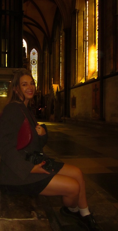 Ella Carrigan seated with her camera inside Salisbury Cathedral