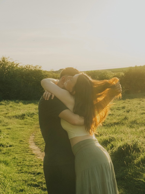 A couple embracing at golden hour in a meadow